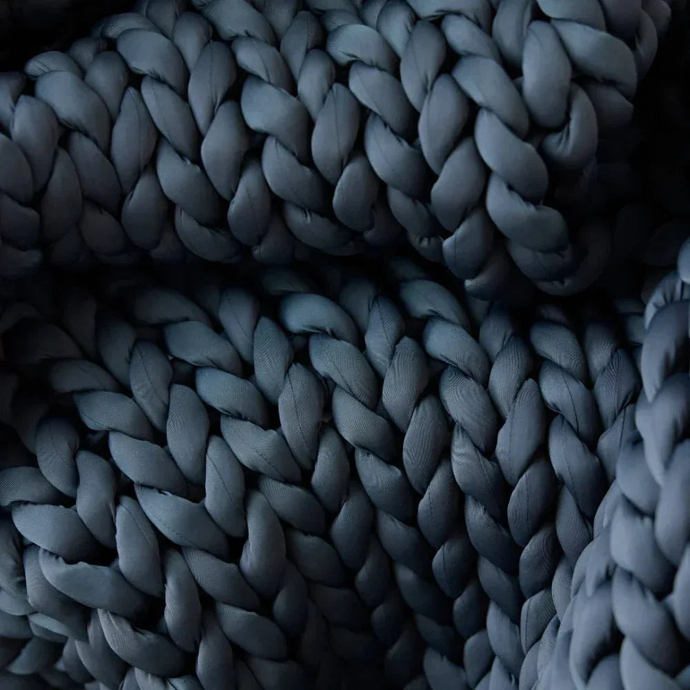 Close-up of chunky knit cooling weighted blanket in dark grey color
