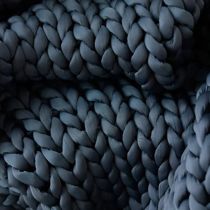Close-up of chunky knit cooling weighted blanket in dark grey color