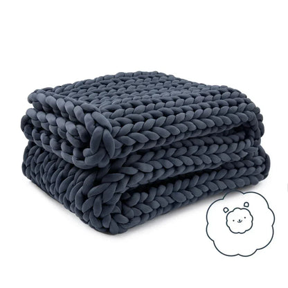 Dark grey chunky knit cooling weighted blanket neatly folded on white background with a cute sheep icon.