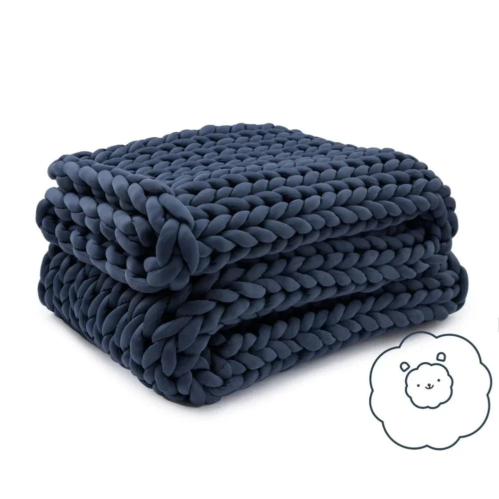 Folded chunky knit cooling weighted blanket in navy blue on white background
