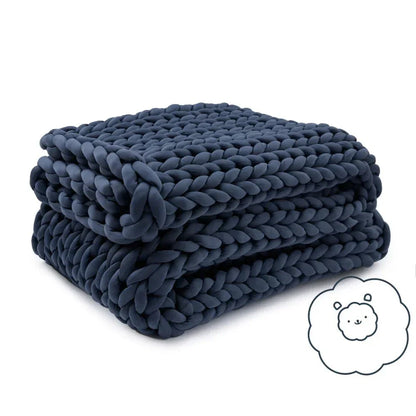 Folded chunky knit cooling weighted blanket in navy blue on white background
