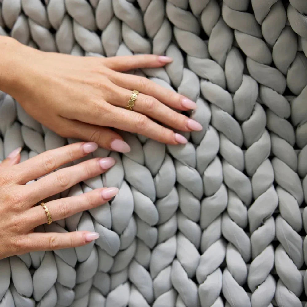 Hands touching chunky knit silver grey cooling weighted blanket for sensory comfort