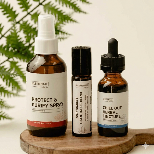 Three amber glass essential oil bottles from Elemental on a wooden board, with fern leaves in the background. The bottles include Protect & Purify Spray, Anti-Anxiety Essential Oil Blend, and Chill Out Herbal Tincture.
