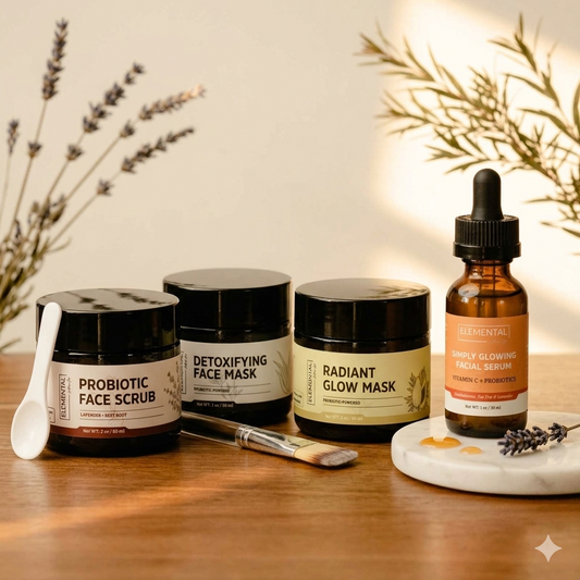 Four skincare products from the brand Eclaloo are arranged on a wooden table with decorative dried lavender branches. The products include Probiotic Face Scrub, Detoxifying Face Mask, Radiant Glow Mask, and Simply Glowing Facial Serum in an amber dropper bottle.