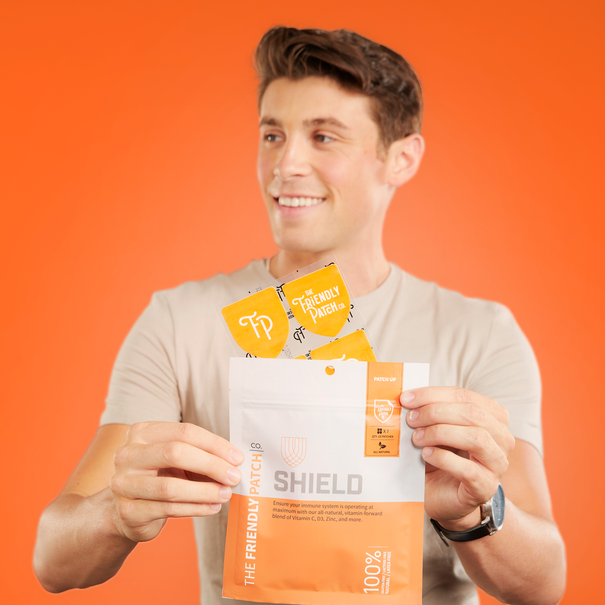 Man holding a package labeled 'SHIELD' against an orange background