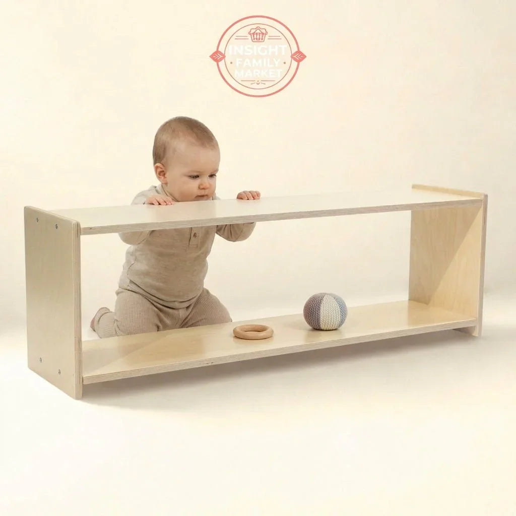 Baby kneeling by Montessori-style wooden shelf with sensory toys in neutral space