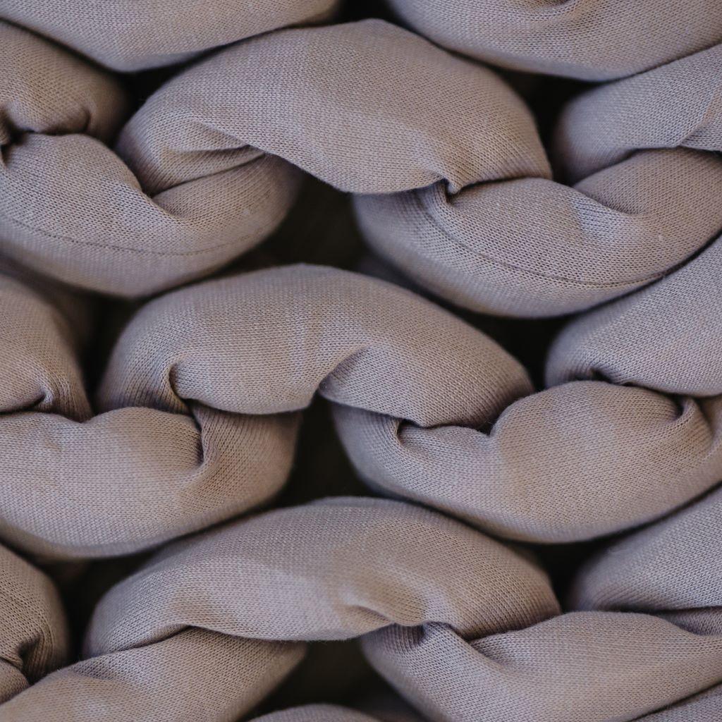 Close-up of dusty rose chunky knit sensory blanket, soft braided cotton texture