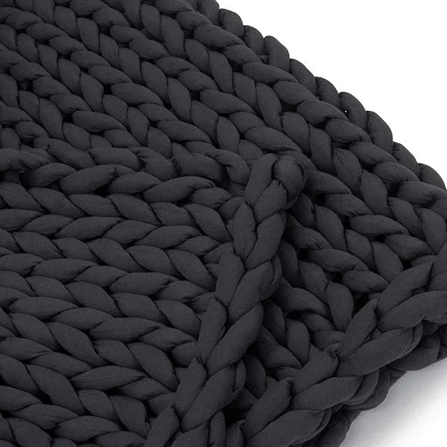 Closeup of a chunky knit charcoal weighted blanket, soft sensory-friendly texture