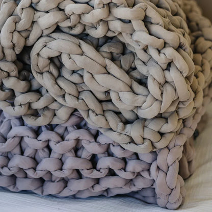 Closeup of chunky knit dusty rose weighted blanket on a bed