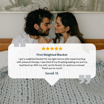 Couple relaxing in bed under chunky grey weighted blanket, five-star testimonial overlay.