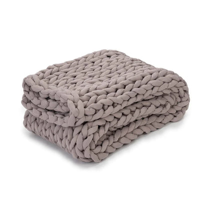 Dusty rose chunky knit weighted blanket folded on a white background, sensory-friendly bedding
