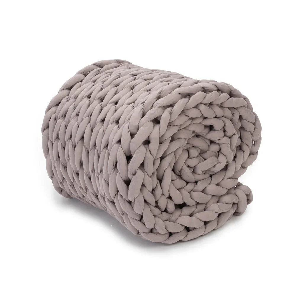 Dusty rose chunky knit weighted blanket rolled up on white background