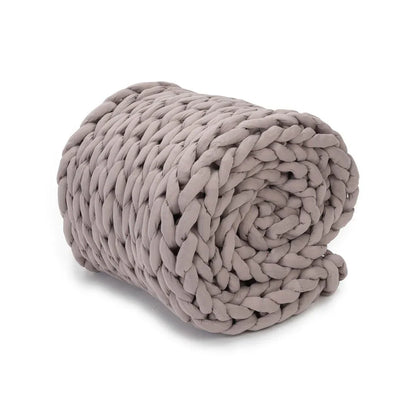 Dusty rose chunky knit weighted blanket rolled up on white background