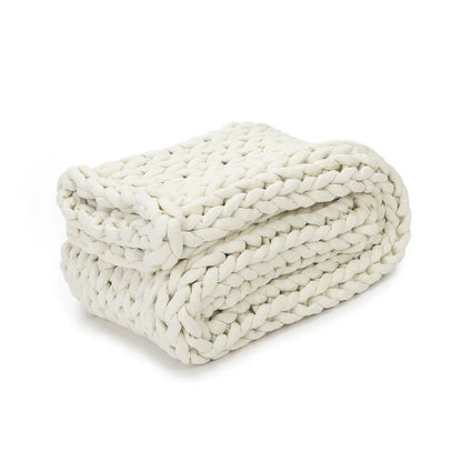 Folded chunky knit cream weighted blanket on white background