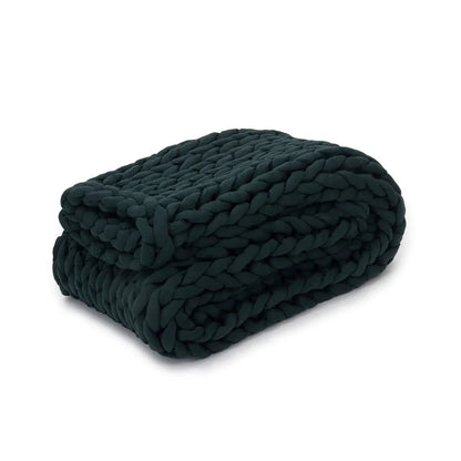 Folded forest green chunky knit weighted sensory blanket on white background