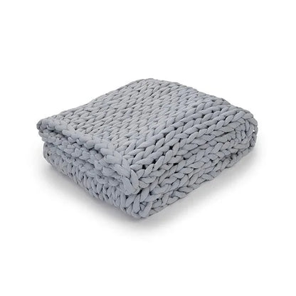 Folded light gray chunky knit weighted blanket on white background