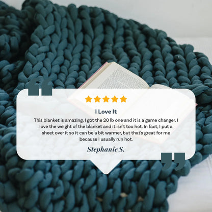 Forest green chunky knit weighted blanket on bed with open book and customer review.