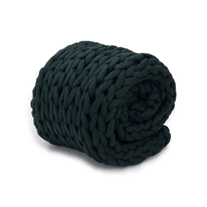 Forest green chunky knit weighted blanket rolled up on a white background