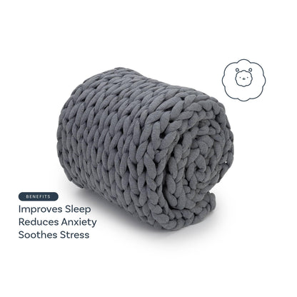Heather grey chunky weighted blanket rolled up, benefits listed: improves sleep, reduces anxiety, soothes stress.