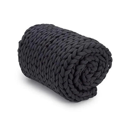 Rolled chunky knit charcoal weighted blanket on a white background