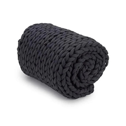 Rolled chunky knit charcoal weighted blanket on a white background