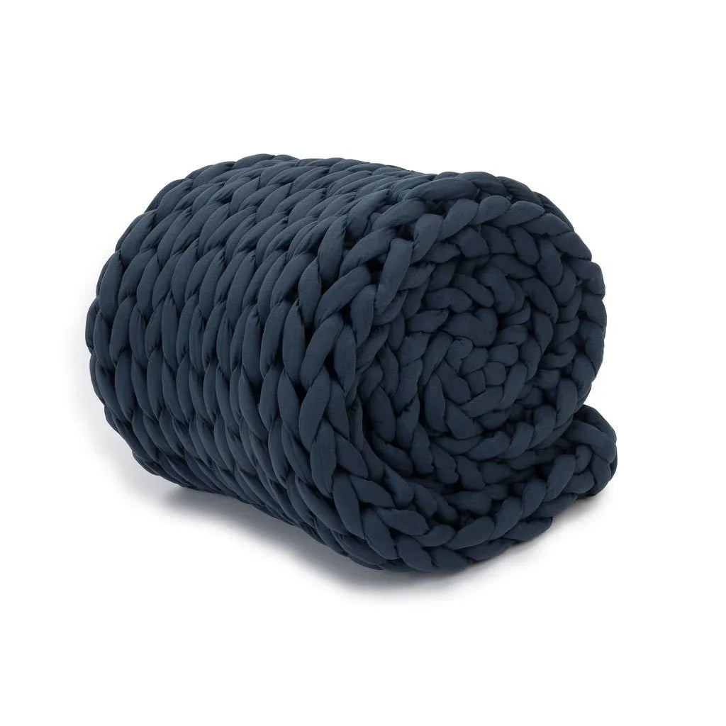 Rolled chunky knit dusty blue weighted blanket on a white background