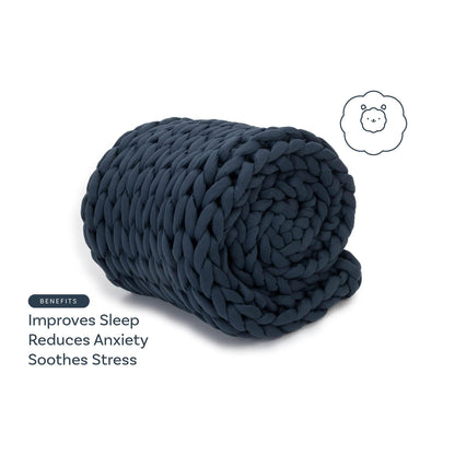 Rolled chunky knit dusty blue weighted blanket on white background, benefits listed: improves sleep, reduces anxiety, soothes stress.