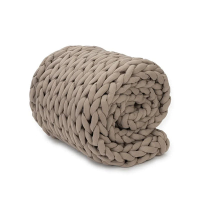 Taupe chunky knit weighted blanket rolled up on a white background, sensory-friendly bedding.