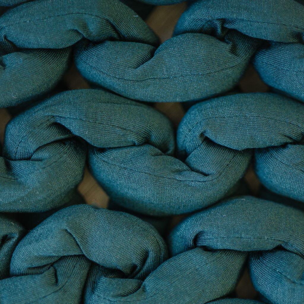closeup of chunky forest green sensory blanket with soft textured knit fabric