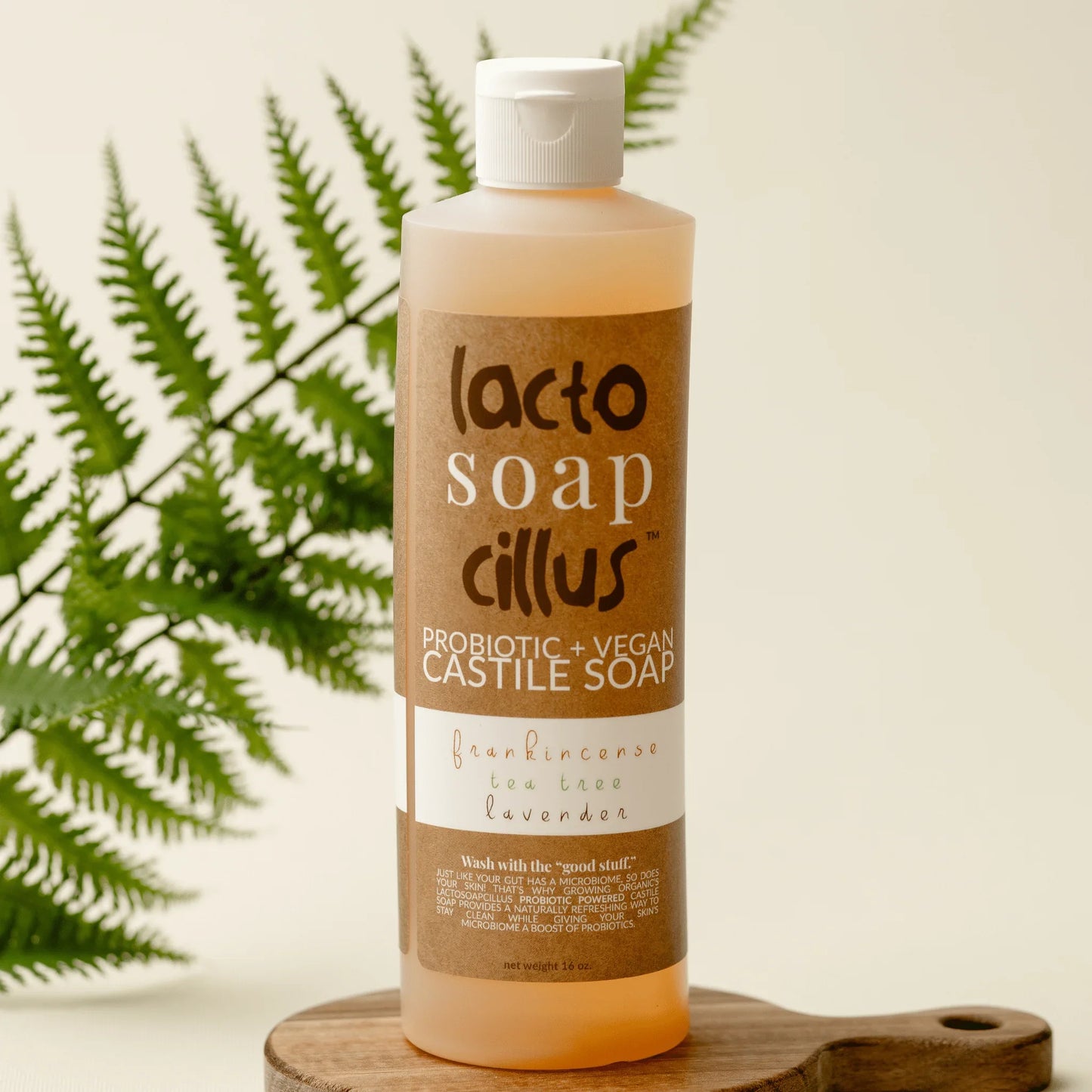 16 oz probiotic vegan castile soap with frankincense, tea tree, and lavender on wood tray