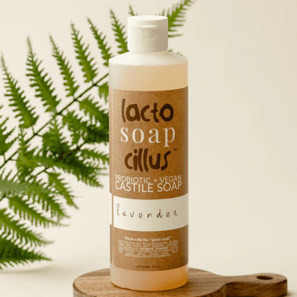 Lavender probiotic vegan Castile soap bottle on wooden tray with green fern leaf