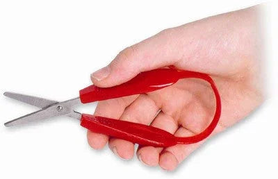 Hand holding red mini Easi-Grip scissors with ergonomic handle, adaptive tool