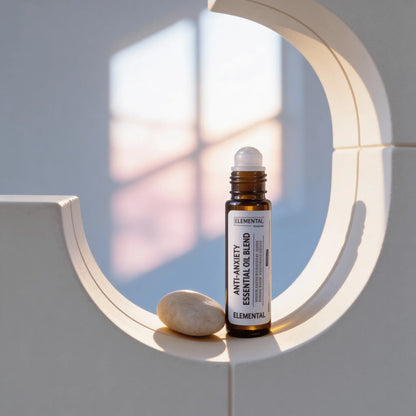 Anti-anxiety essential oil blend roller bottle with smooth stone in sunlit minimalist setting