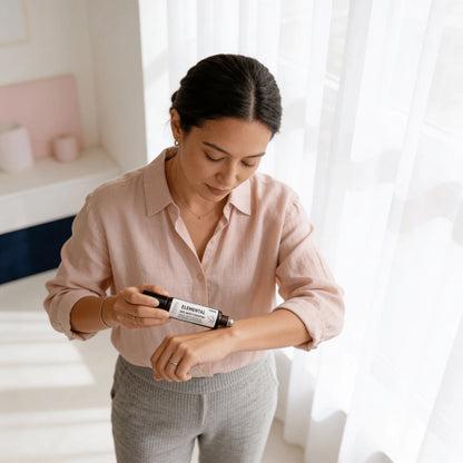 Woman applying Elemental magnesium oil for sensory wellness on arm in bright room