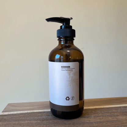 Amber glass pump bottle of organic hexane-free castor oil on a wooden surface