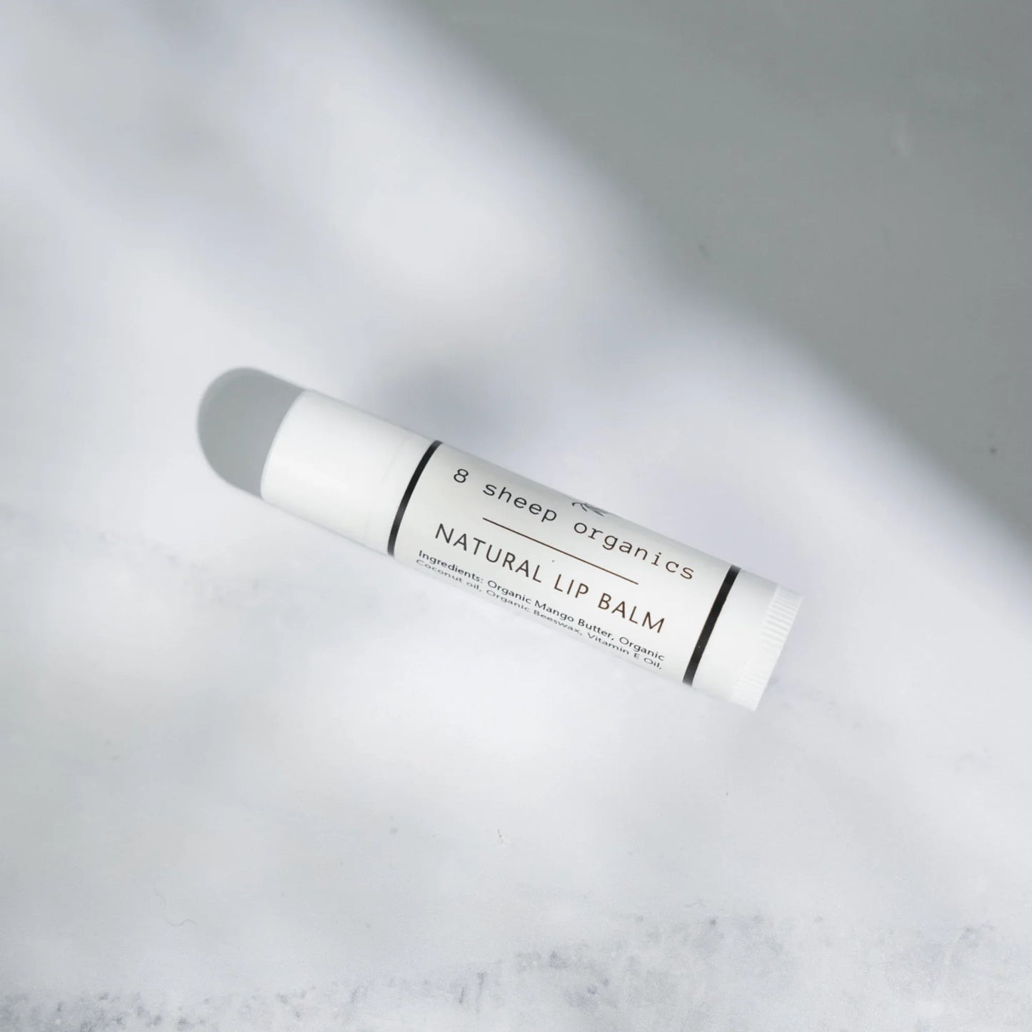 Natural lip balm tube with organic ingredients on a white background