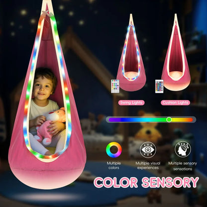 Child in pink sensory swing with LED lights, holding plush toy in cozy bedroom, color sensory