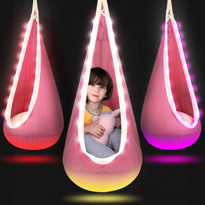 Child sitting in a pink sensory pod swing with LED lights, holding a stuffed toy