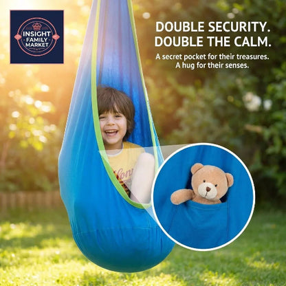 Child smiling in a blue sensory swing with security pocket holding a teddy bear outdoors.