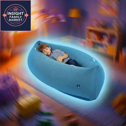 Child relaxing in blue sensory calming pod in vibrant playroom, holding a book