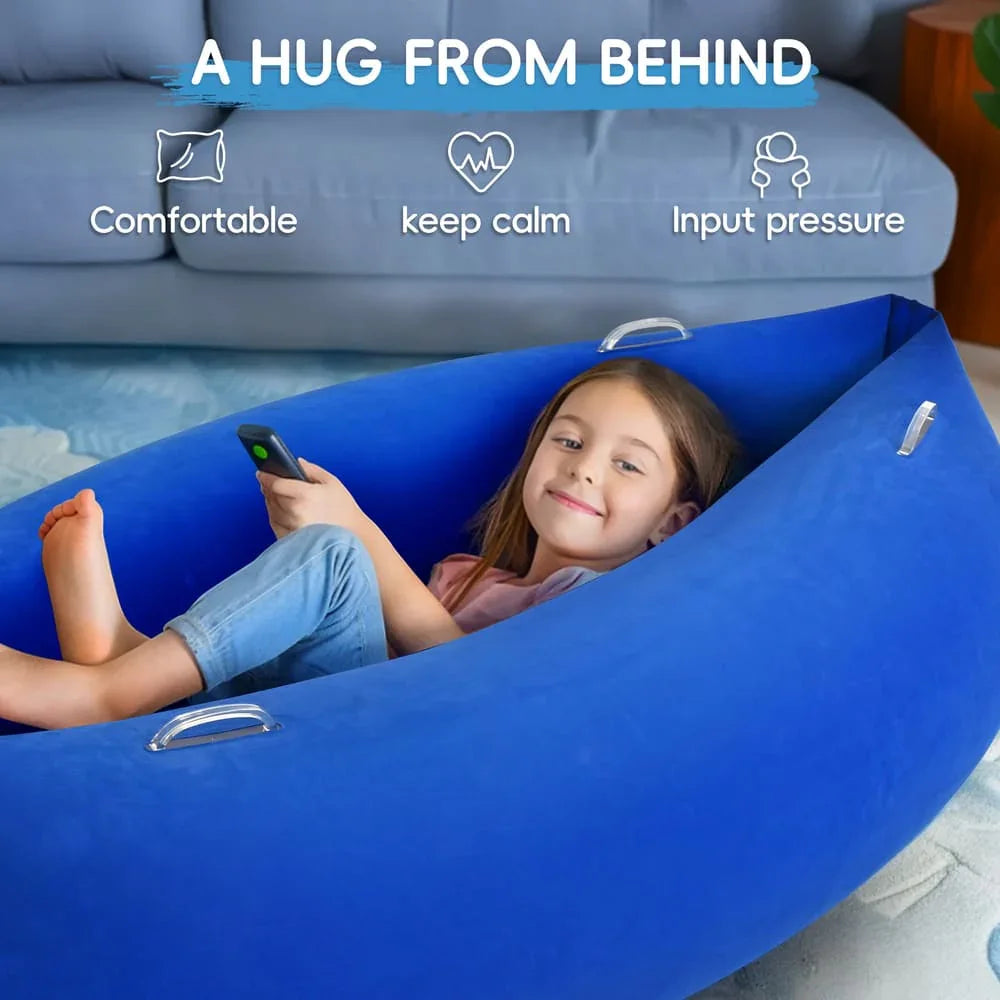 Smiling child relaxing in a sensory blue inflatable hug chair in a living room