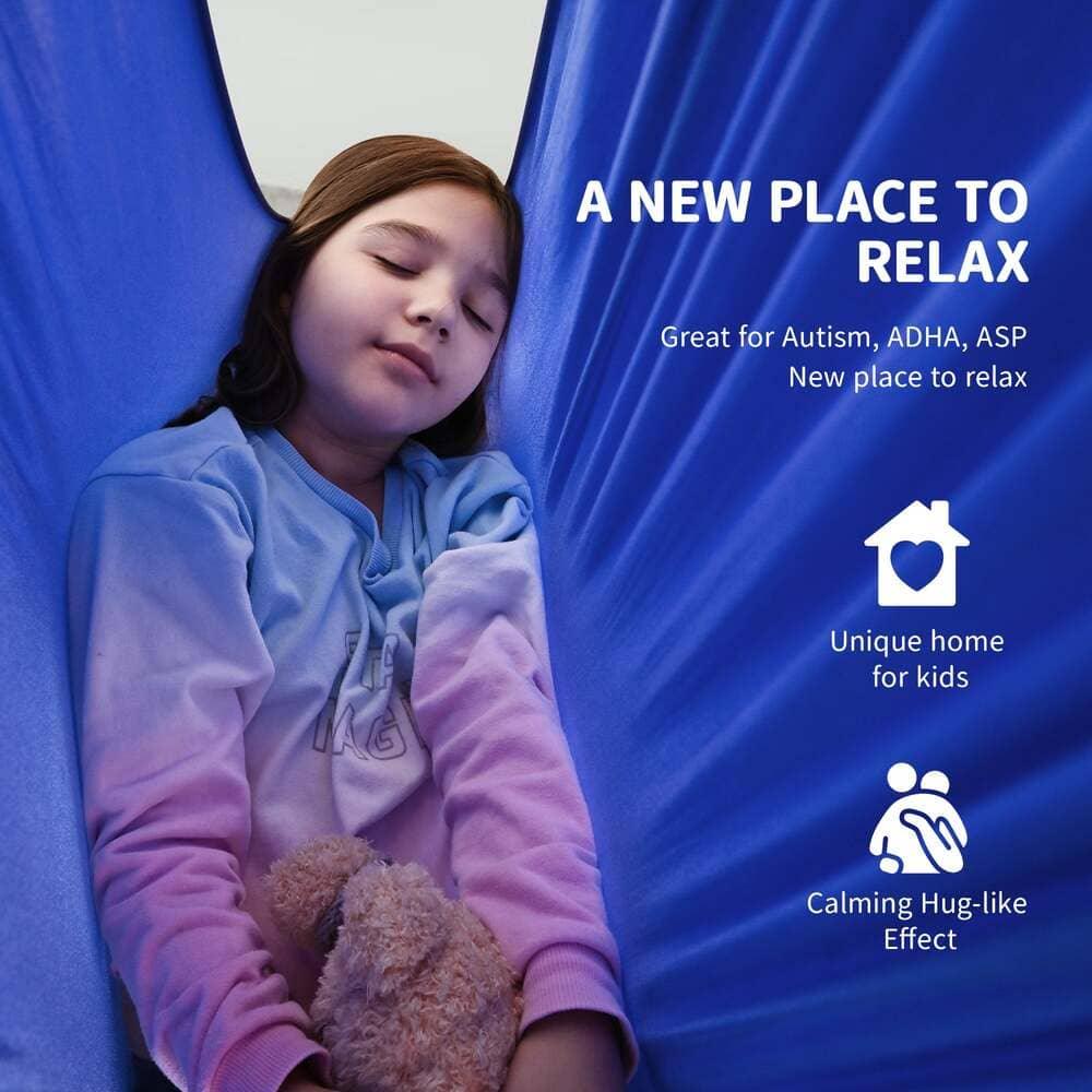 Girl relaxing in blue sensory swing, eyes closed, holding teddy bear, promoting calming effect for kids.
