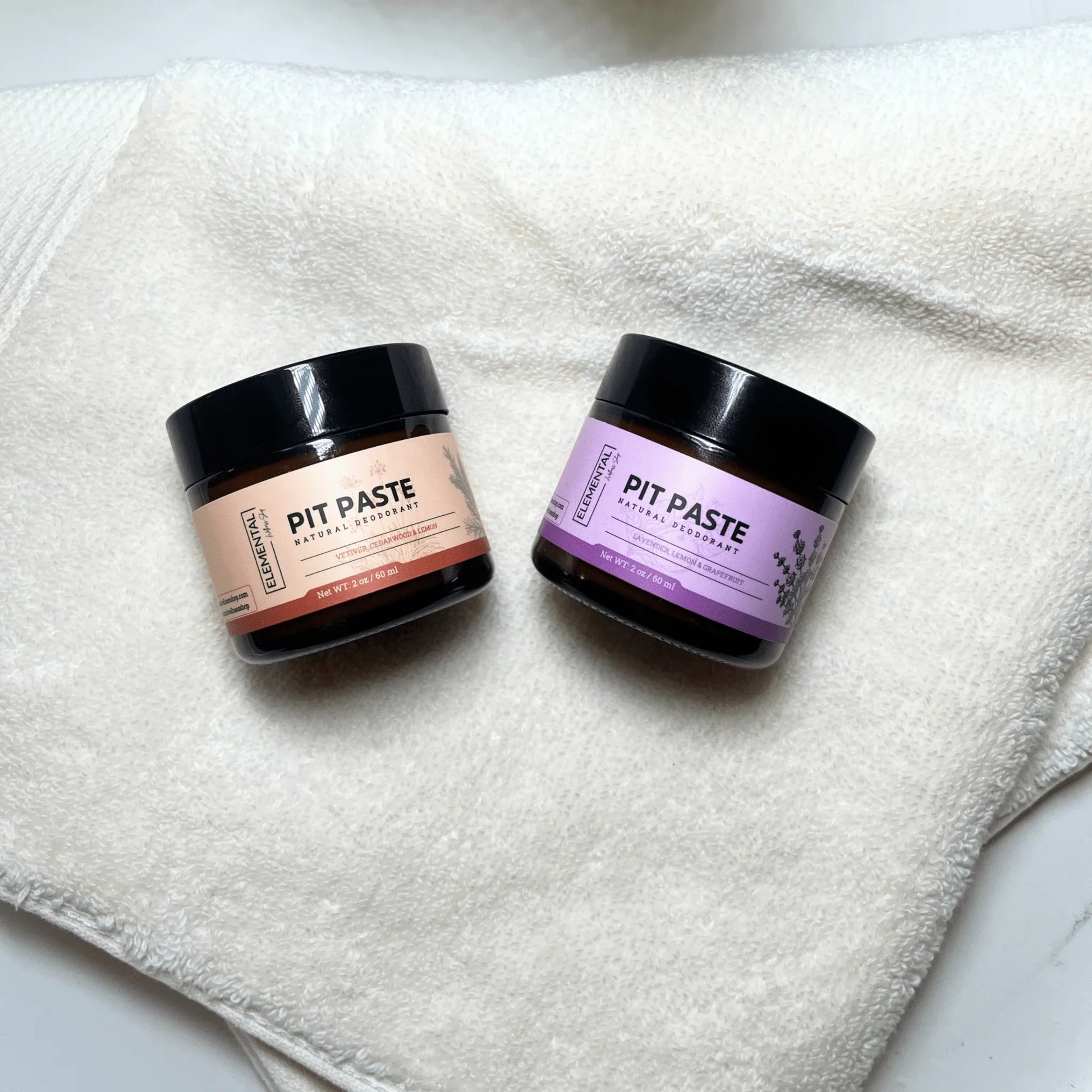 Two Elemental Wellness Pit Paste all natural deodorant jars on a white towel
