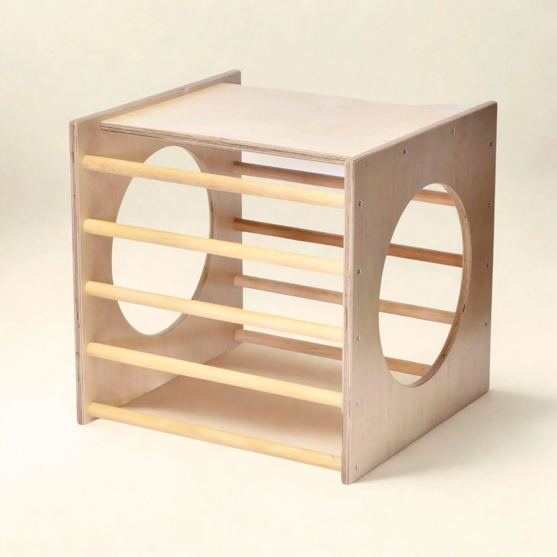 Wooden Pikler play cube with climbing bars and round sensory-friendly cutouts