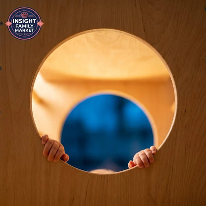 Child’s hands holding sensory play tunnel, wooden calm space for kids’ sensory needs