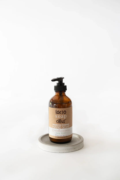 Probiotic powered hand soap bottle for sensitive skin with brown label on round tray