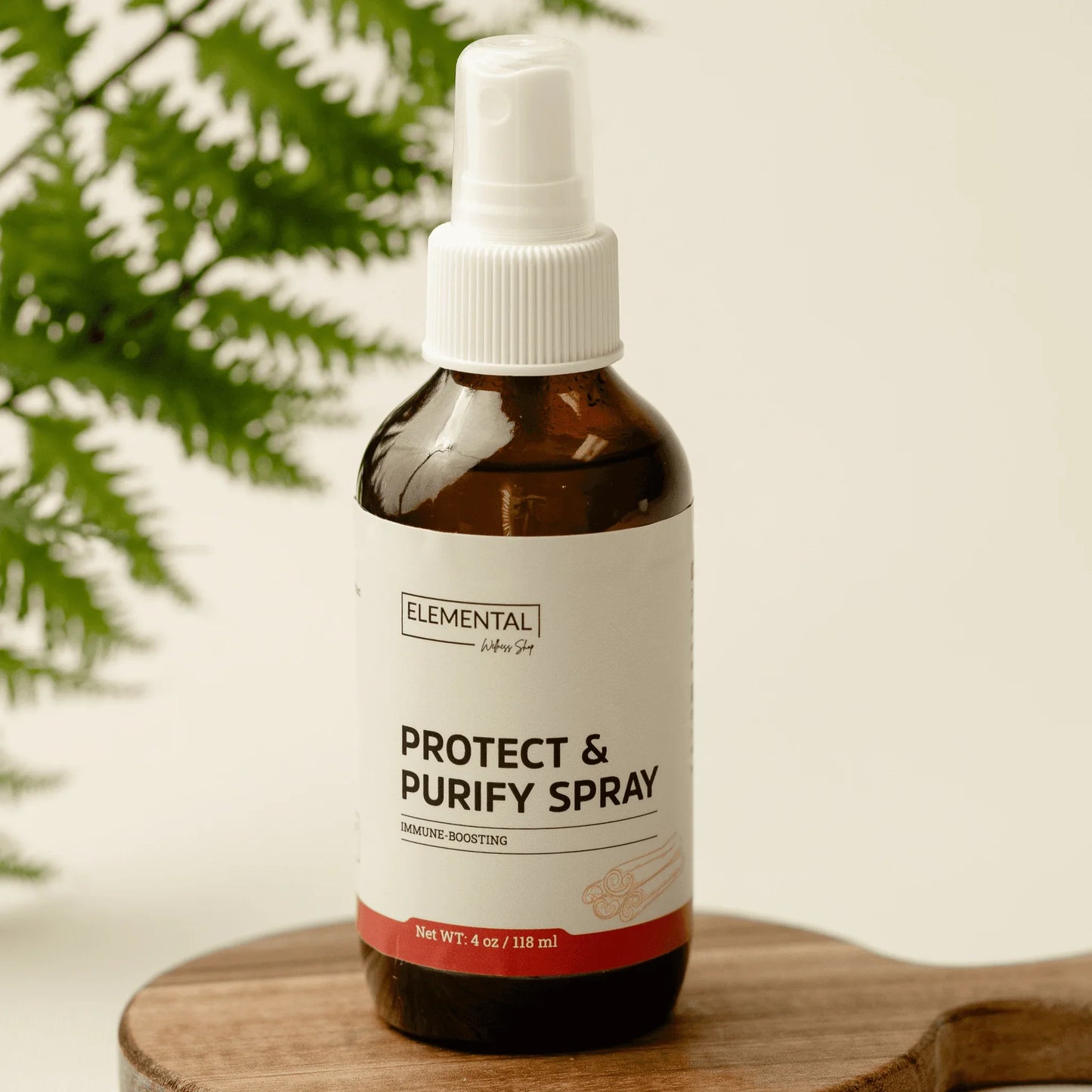 Protect & Purify Spray natural immune support bottle on wood tray with green fern