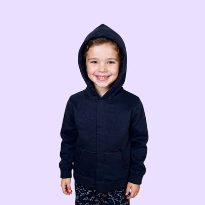 Smiling child in sensory-friendly navy zip-up hoodie on light purple background