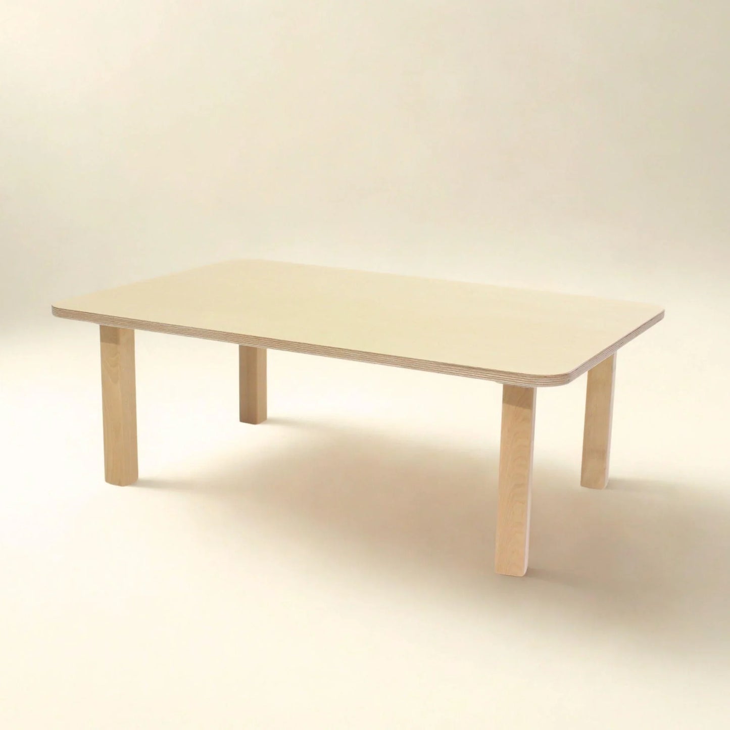 Rectangular light wood toddler table with rounded corners on neutral background