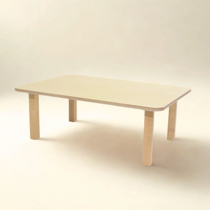 Rectangular light wood toddler table with rounded corners on neutral background